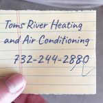 Toms River Heating and Air Conditioning phone number written on a scrap of paper for Manasquan heating repair
